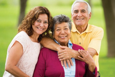 mother, father, and adult daughter smiling for photo